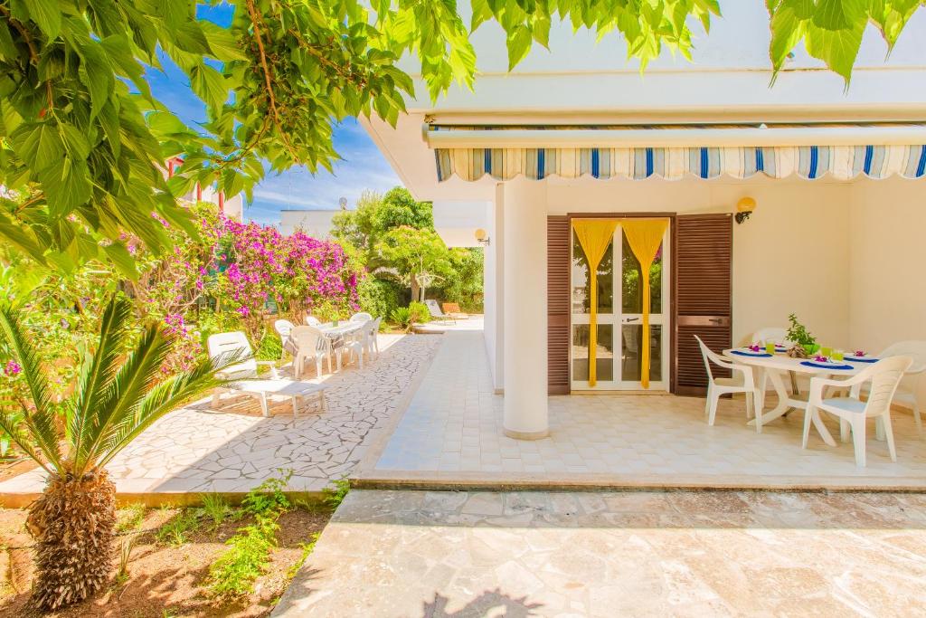 a patio of a house with a table and chairs at Villa Irene in Torre Santa Sabina