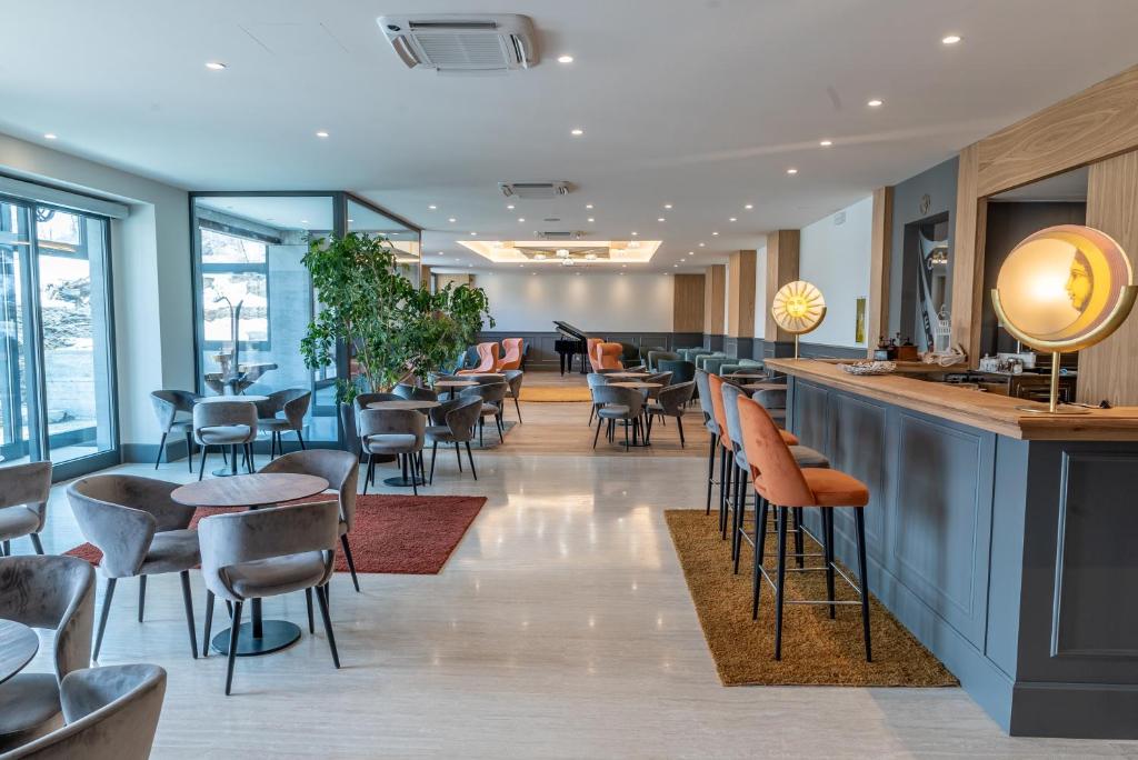 bar w restauracji z krzesłami i stołami w obiekcie Cristallo Wellness Hotel w mieście Aprica