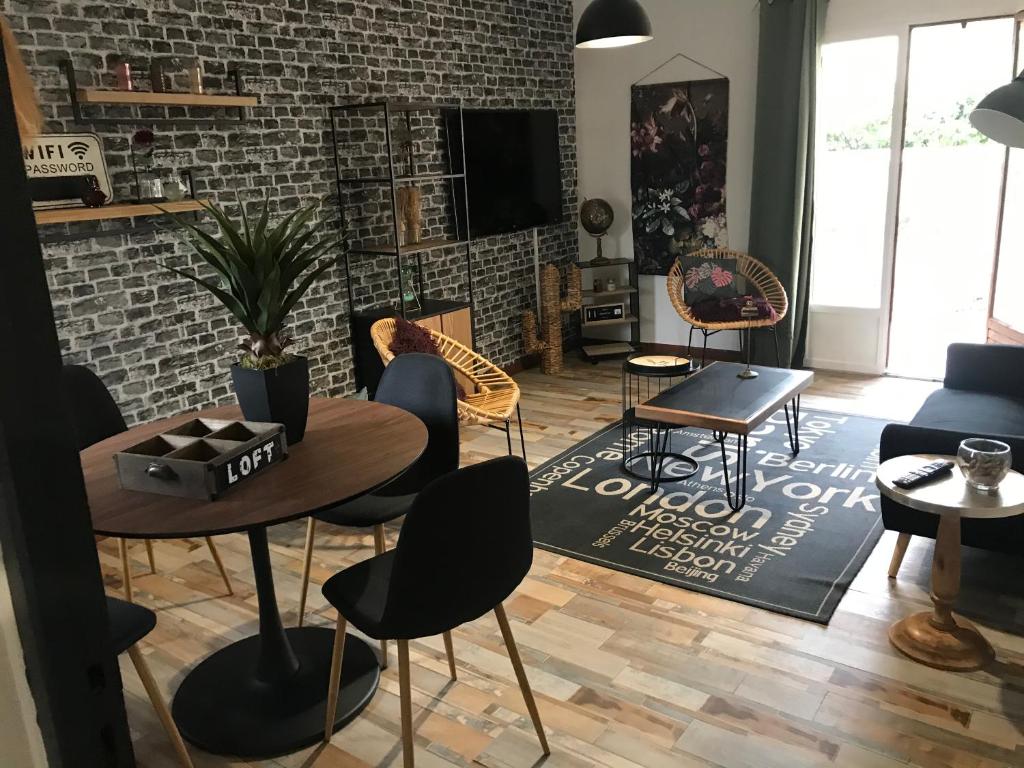 una sala de estar con mesas, sillas y una pared de ladrillo. en Marina, en Narbona
