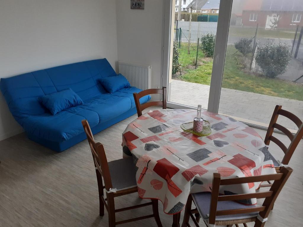 a living room with a table and a blue couch at Teranga in Berck-sur-Mer