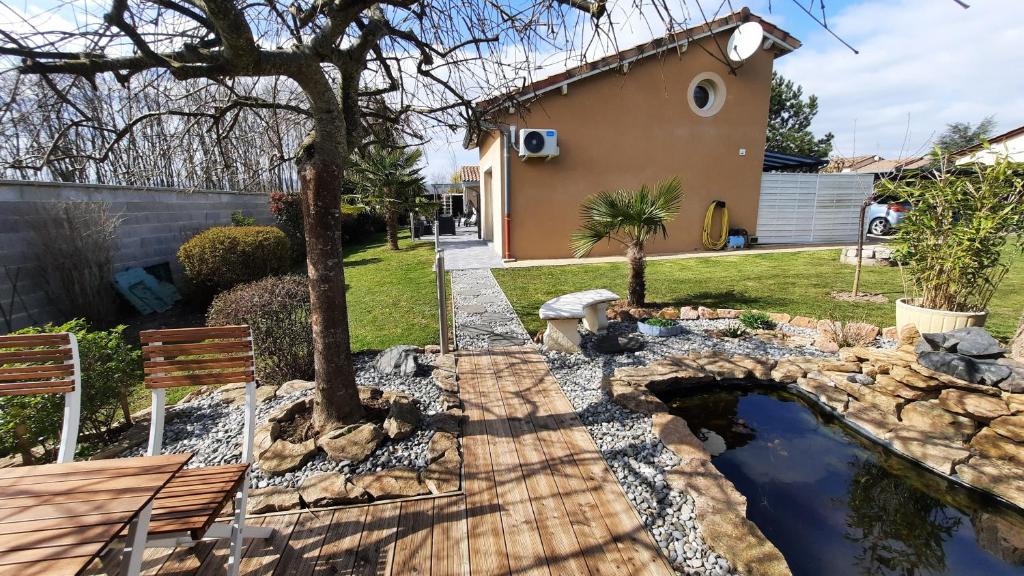 einen Hof mit einem Teich und einem Haus in der Unterkunft La Datcha d'Elena in La Chapelle-de-Guinchay