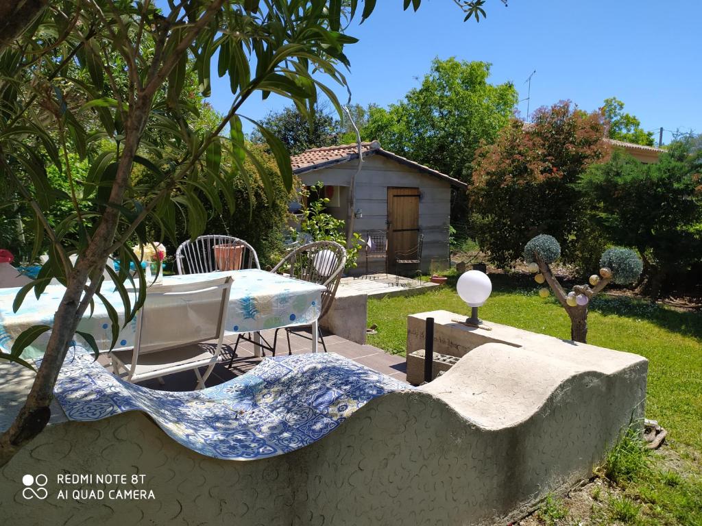 a garden with a table and chairs in a yard at Villa de charme avec piscine in Ghisonaccia