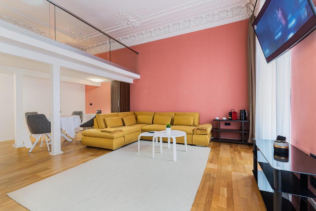 布拉索夫的住宿－Palazzo Brașov，客厅设有黄色沙发和电视