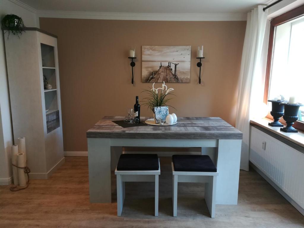 a kitchen island with two stools and a table at 2 Zimmer Ferienwohnung Ostseetraum Haffkrug in Scharbeutz