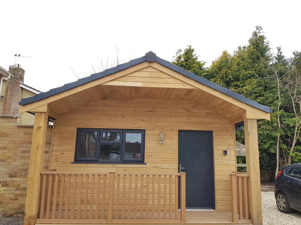 a large wooden shed with a black door at Wyvern Apartment in Yeovil