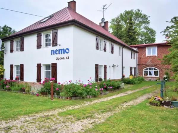 a white house with a sign on the side of it at Nemo Mielenko in Mielenko