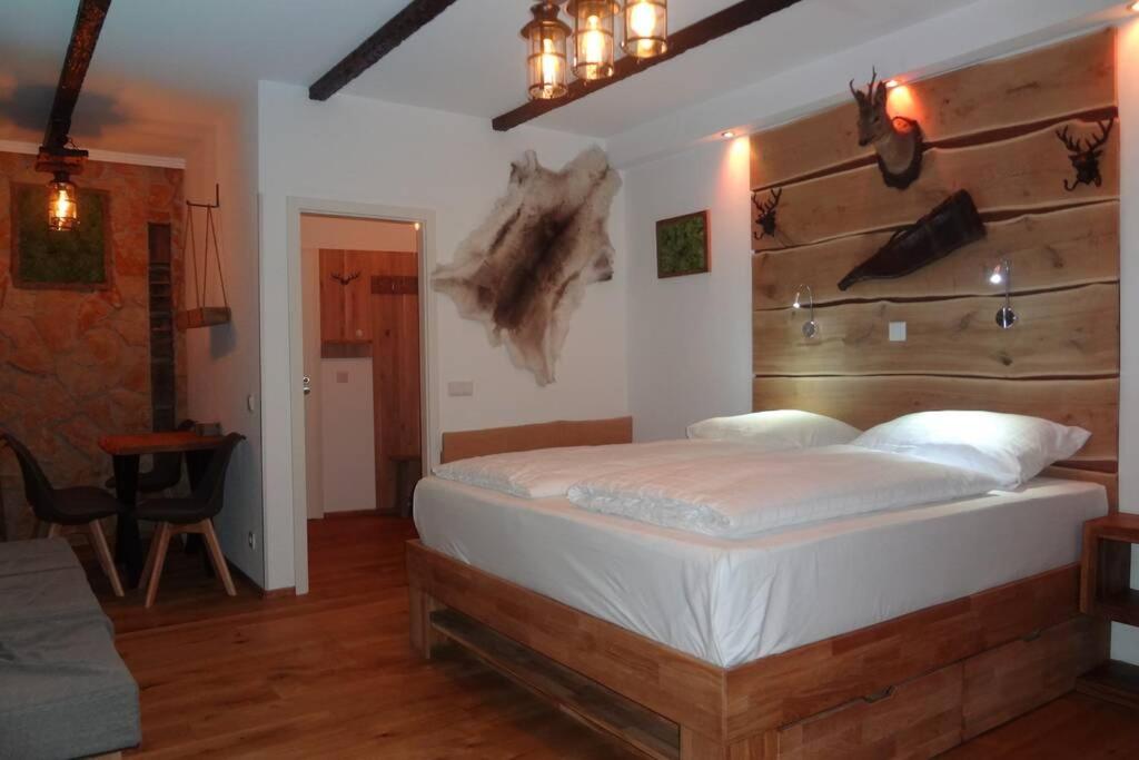 a bedroom with a large bed with a wooden headboard at Charmante rustikale Jägersuite mit el Kamin H2O Therme Oberhof in Oberhof