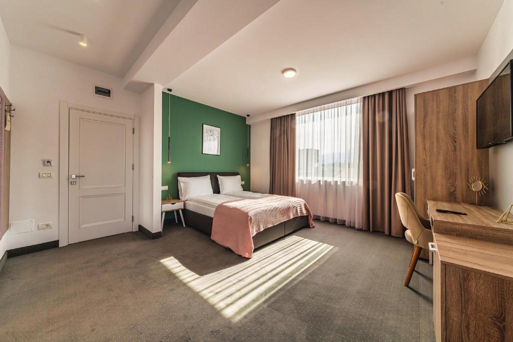 a bedroom with a bed and a green wall at Saga Rooms in Victoria