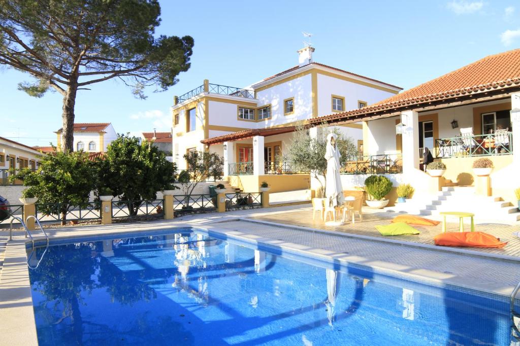 a swimming pool in front of a house at Quinta do Lagar de São José in Paialvo