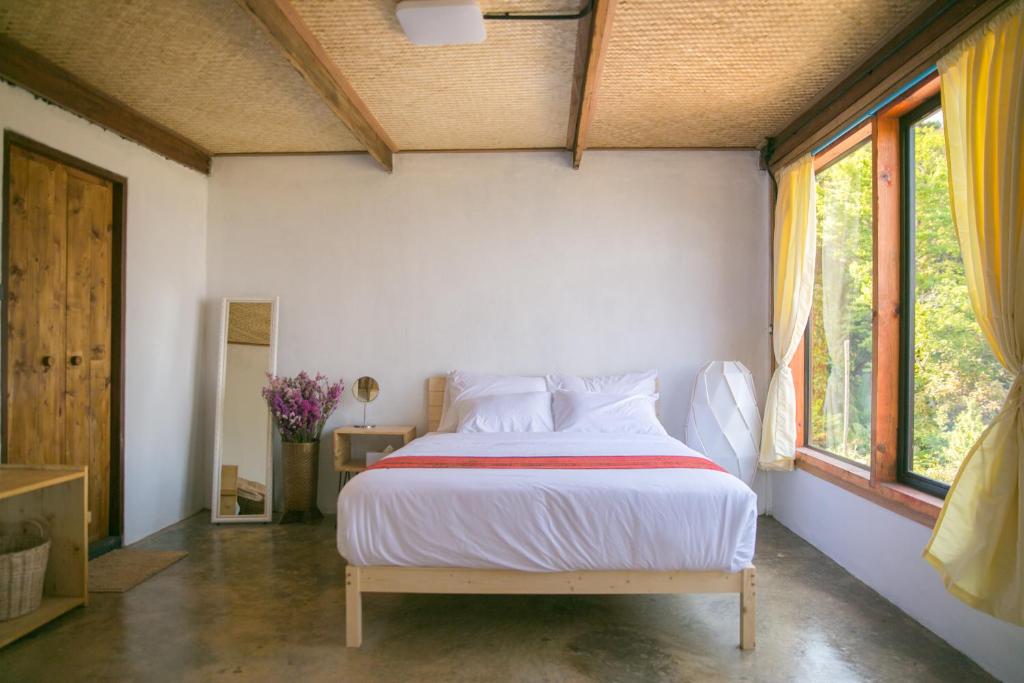 une chambre avec un lit avec des draps blancs et une fenêtre dans l'établissement ไร่ชาดอยอินทนนท์, à Ban Yang Khun Wang