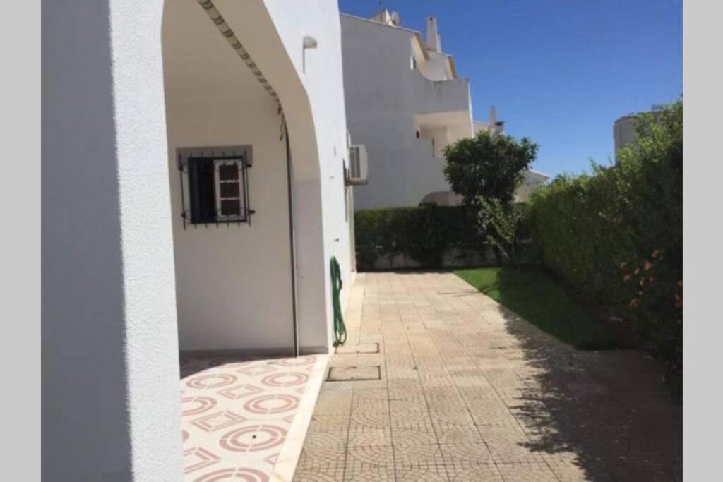 a hallway leading to a white building with an archway at Moradia em Altura! Beach House in Altura