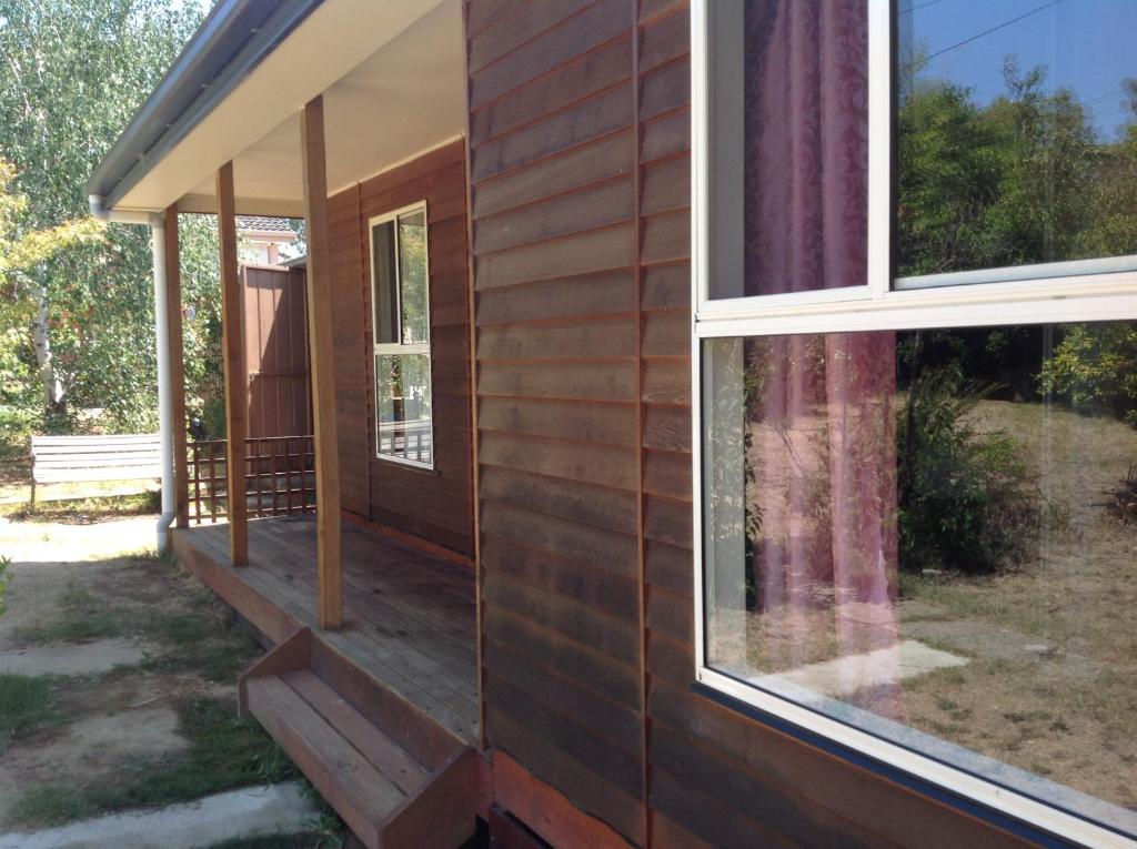 vistas al porche delantero de una casa con ventana en The Cook Cottage, en Canberra