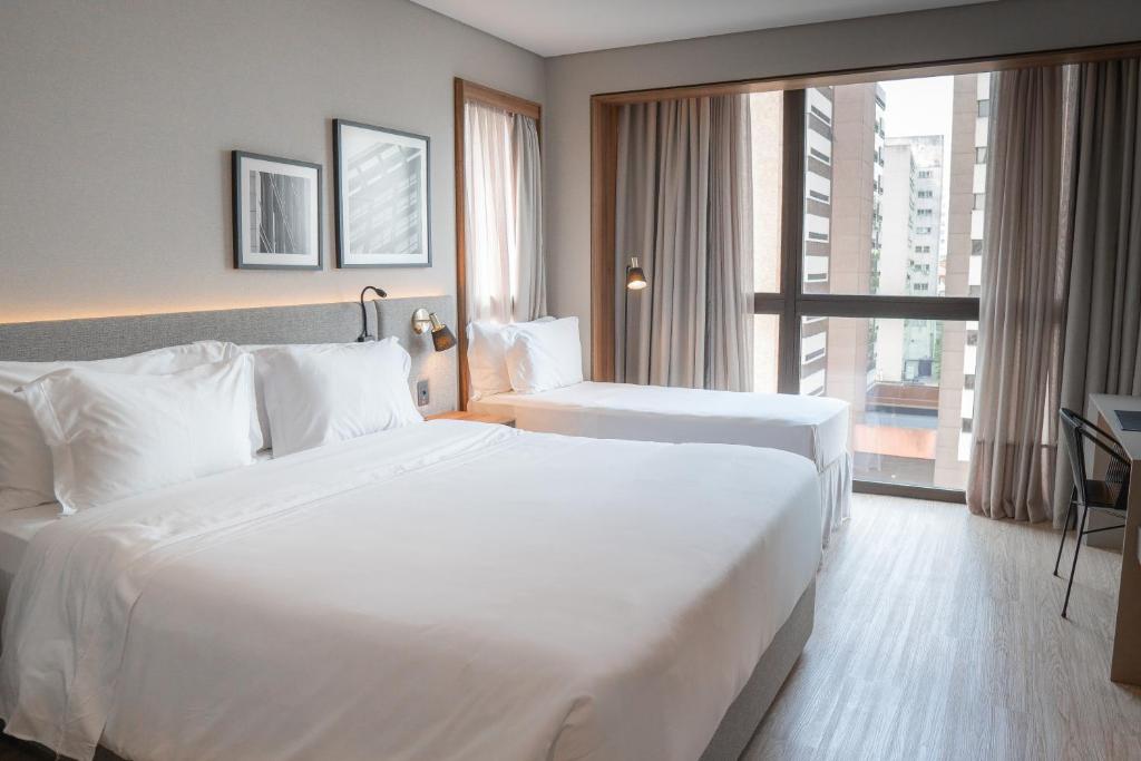 フロリアノポリスにあるLK Design Hotel Florianópolisのベッドが2つと大きな窓があるホテルの部屋