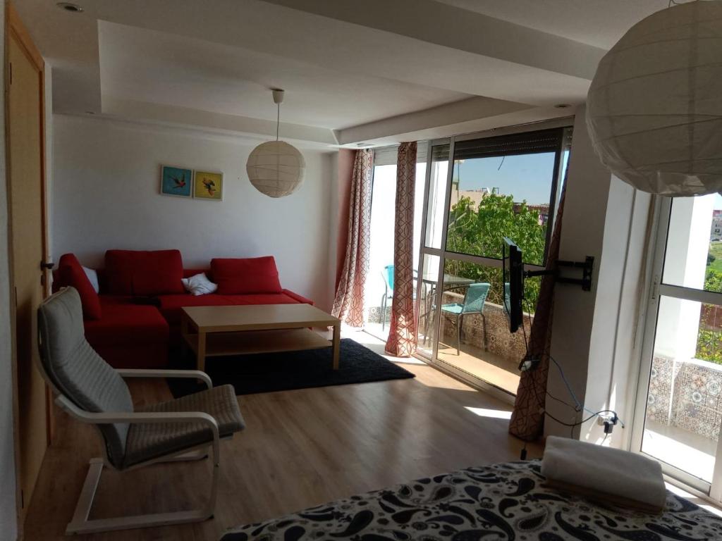 a living room with a red couch and a window at Taza Organic Garden with view park and restaurant in Taza