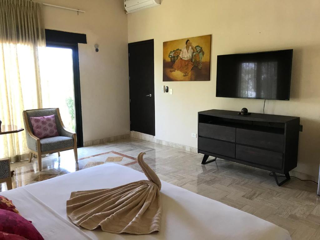 1 dormitorio con 1 cama, vestidor y TV en Real Escondida, en Playa del Carmen