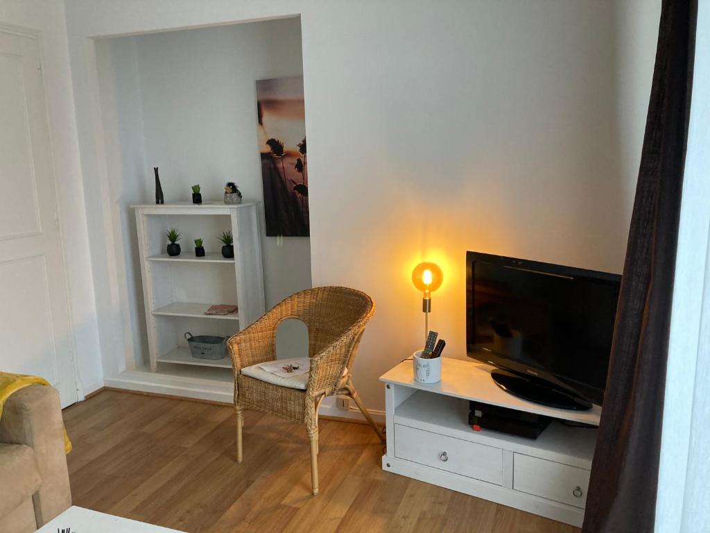 a living room with a television and a desk with a chair at Appart Aux deux Colombes avec Balcon et Garage in Pamiers