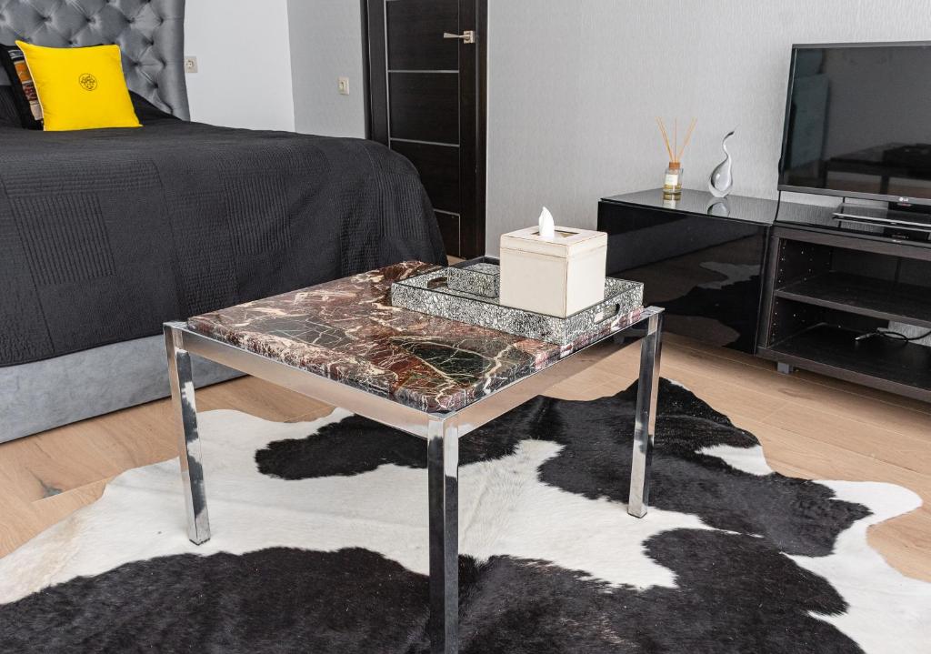 uma sala de estar com uma mesa com uma tampa de vidro em Central Park studio em Gulbene