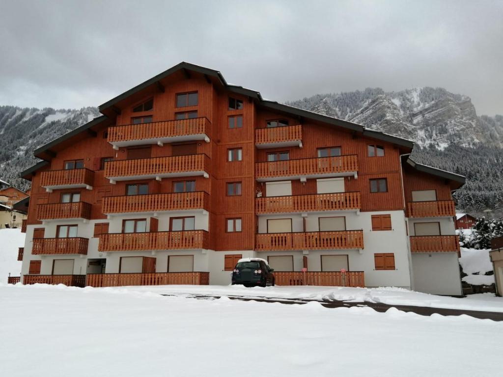 a large building with snow in front of it at Le coeur des Memises in Thollon