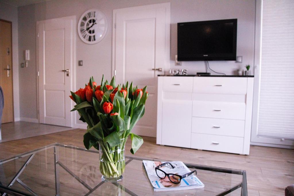 a vase of red tulips sitting on a glass table at APARTAMENT w CENTRUM-GARAŻ in Kielce