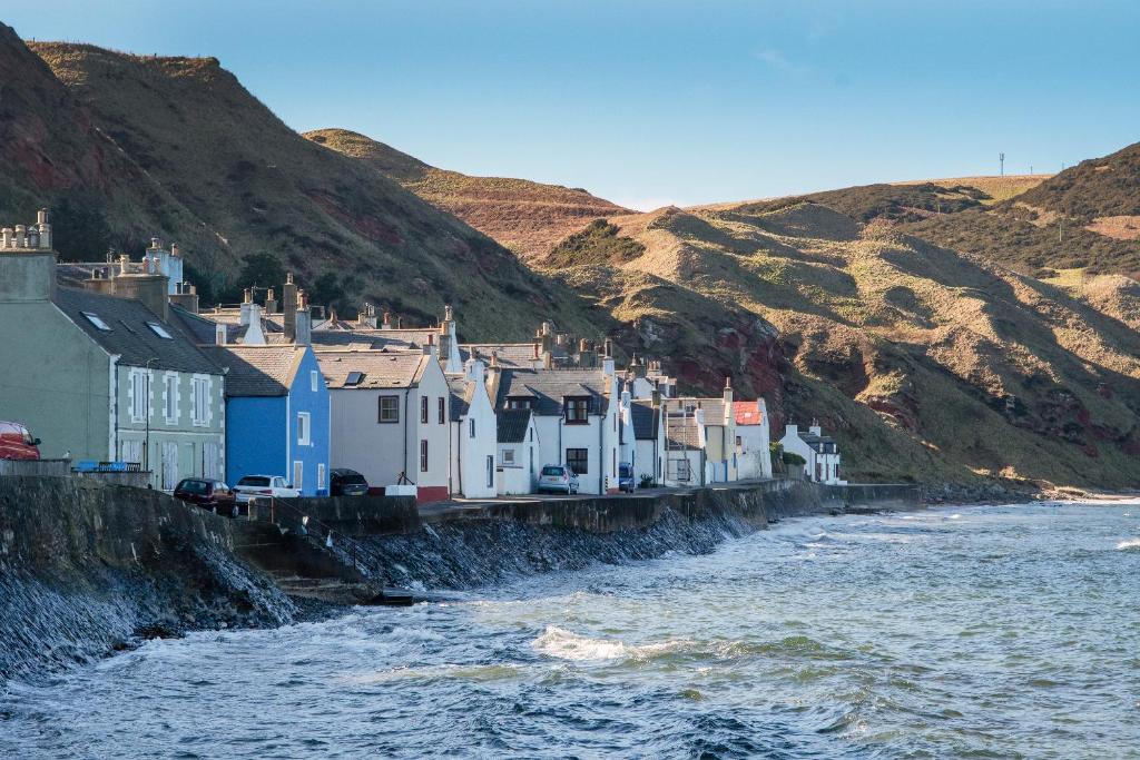 a row of houses on the side of a river at Finest Retreats - Ellie-Jo Cottage in Gardenstown