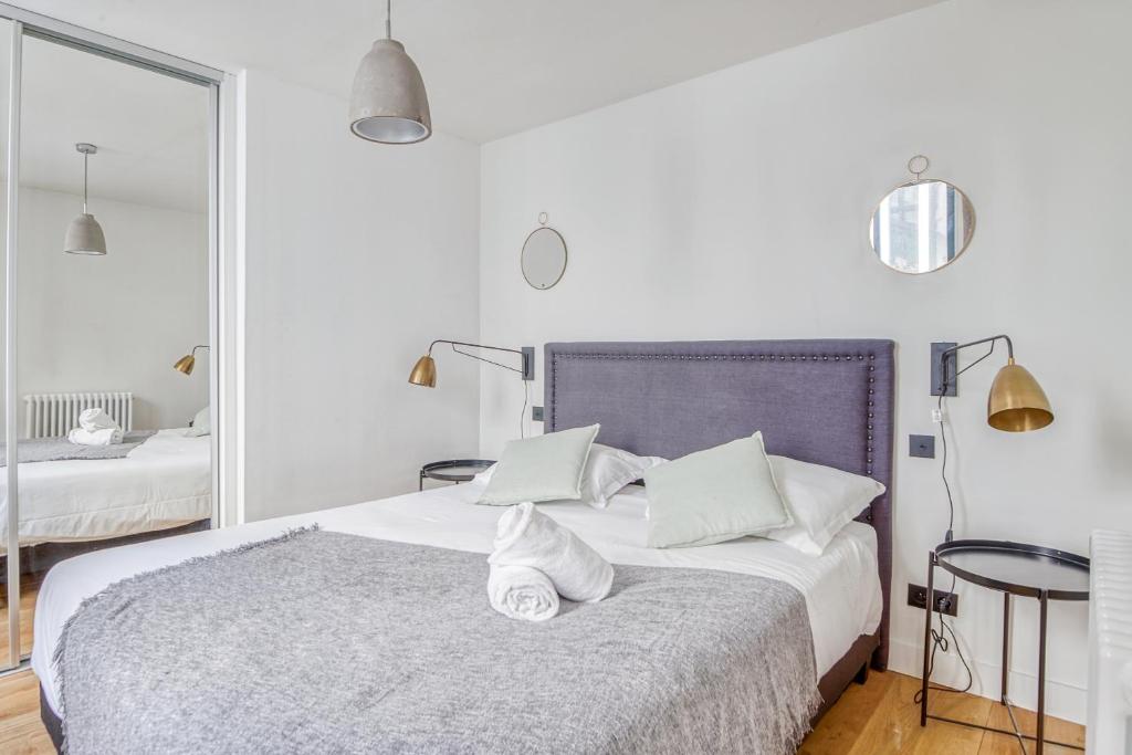 1 dormitorio blanco con 1 cama grande con almohadas blancas en NOCNOC - Le Ténor, Monnaie, en Lille