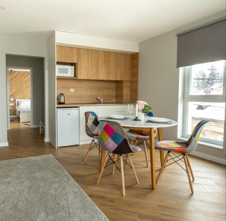 cocina y comedor con mesa y sillas en "The House" Апартаменти и Термална зона, en Velingrad