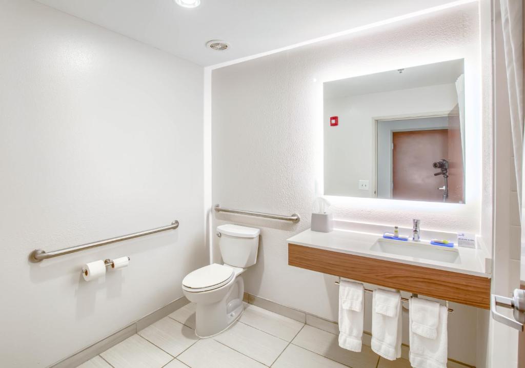 ein Badezimmer mit Toilette, Waschbecken und Spiegel in der Unterkunft Holiday Inn Express Hotel &amp; Suites Gulf Shores by IHG in Gulf Shores