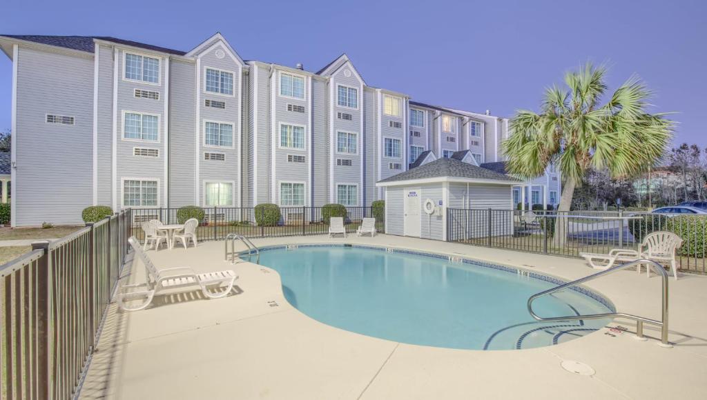 a swimming pool in front of a building at Microtel Inn & Suites by Wyndham Gulf Shores in Gulf Shores