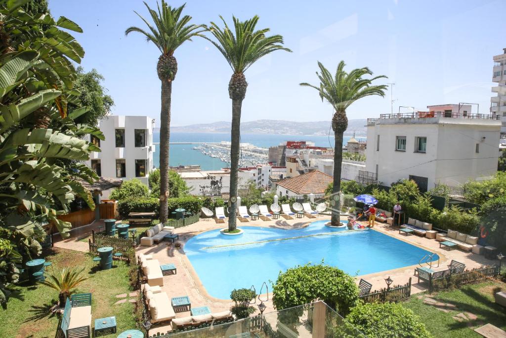 a view of a swimming pool with palm trees at Hôtel Rembrandt in Tangier