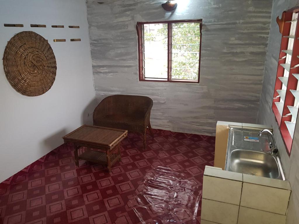 a kitchen with a sink and a chair and a table at La Guesthouse Étoile in Cotonou