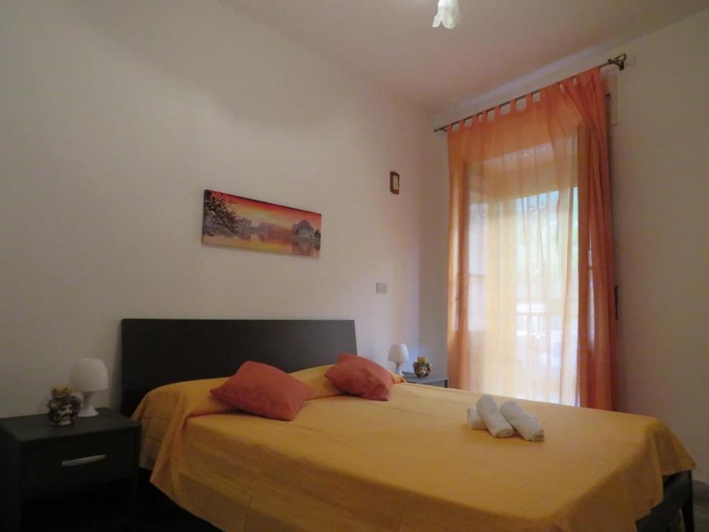 レトイアンニにあるCasa Vacanze Nonna Teresaのベッドルーム1室(オレンジのシーツが入ったベッド1台、窓付)