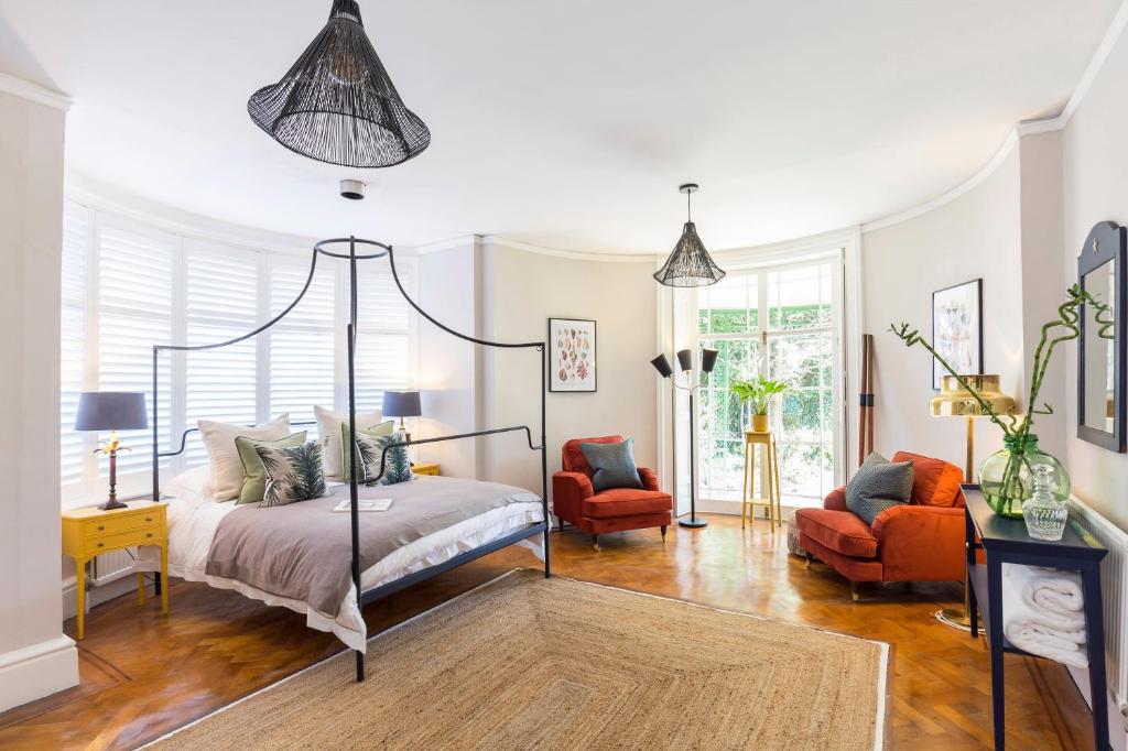 a bedroom with a bed and two chairs at The State Room at Seafield House in Emsworth