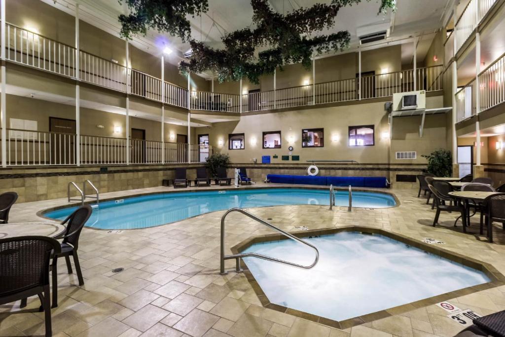 a pool in a hotel room with tables and chairs at Studio 6 - Minot, ND in Minot