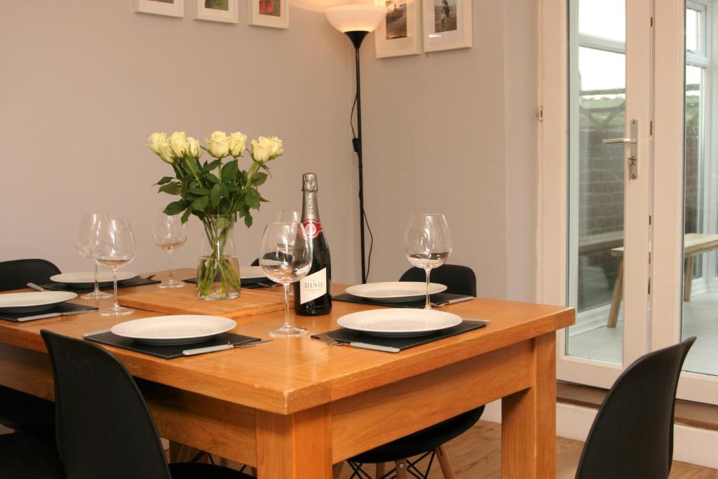 uma mesa de jantar com copos de vinho e flores em Twizell Lane em Beamish