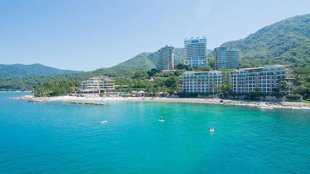a group of buildings on a beach in the water at Suites at Garza Blanca Preserve Resort & Spa in Puerto Vallarta