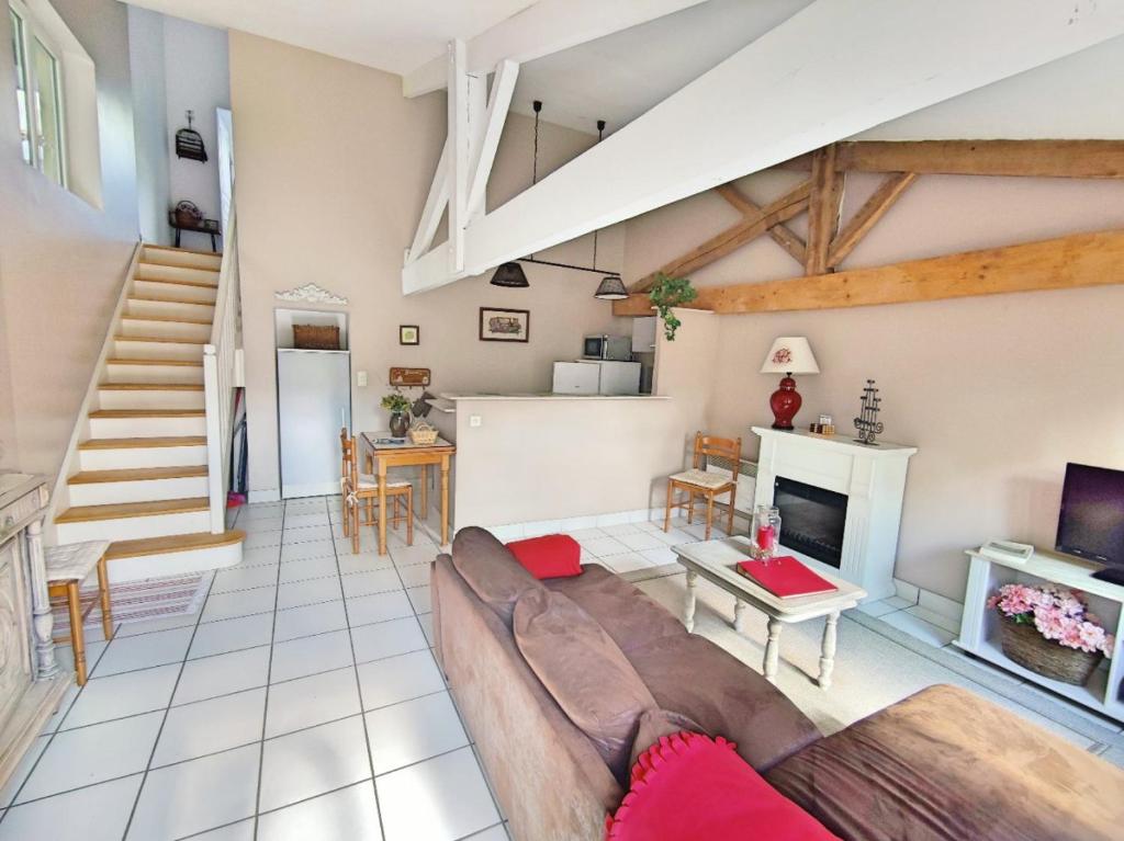 a living room with a couch and a fireplace at Gîte avec piscine et jardin Le Cosy - Les Bergeronnettes Bergerac in Bergerac
