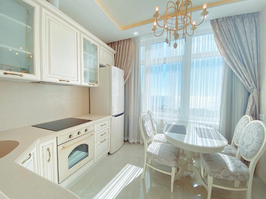 cocina con fregadero, mesa y sillas en Апартаменты у моря, Аркадия, en Odessa