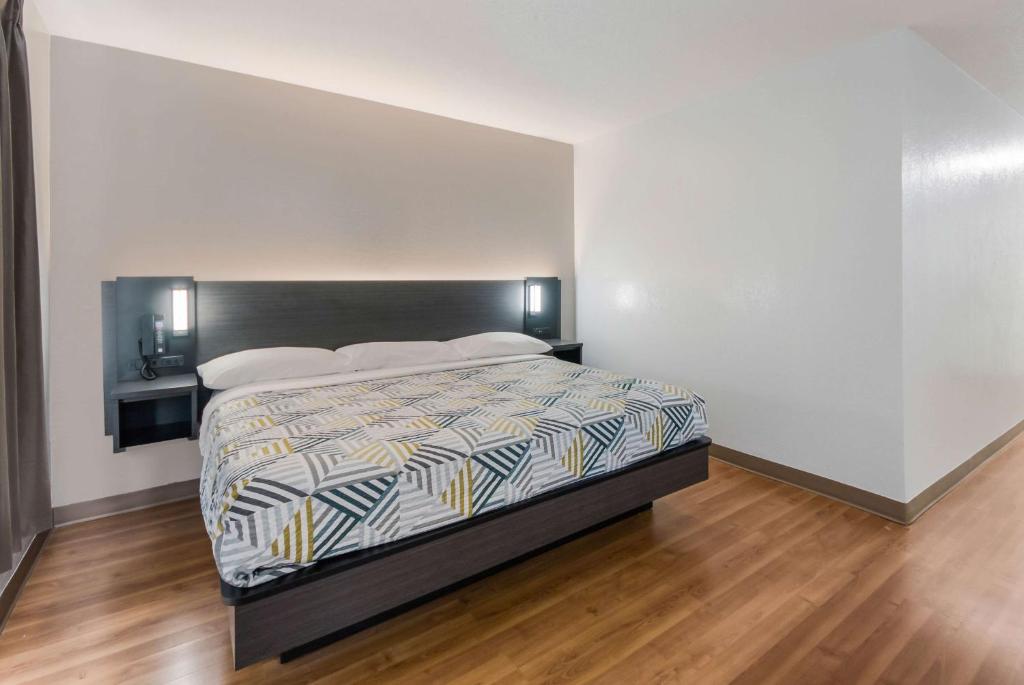 a bedroom with a large bed with a wooden floor at Studio 6 Laredo, Tx - North I-35 in Laredo