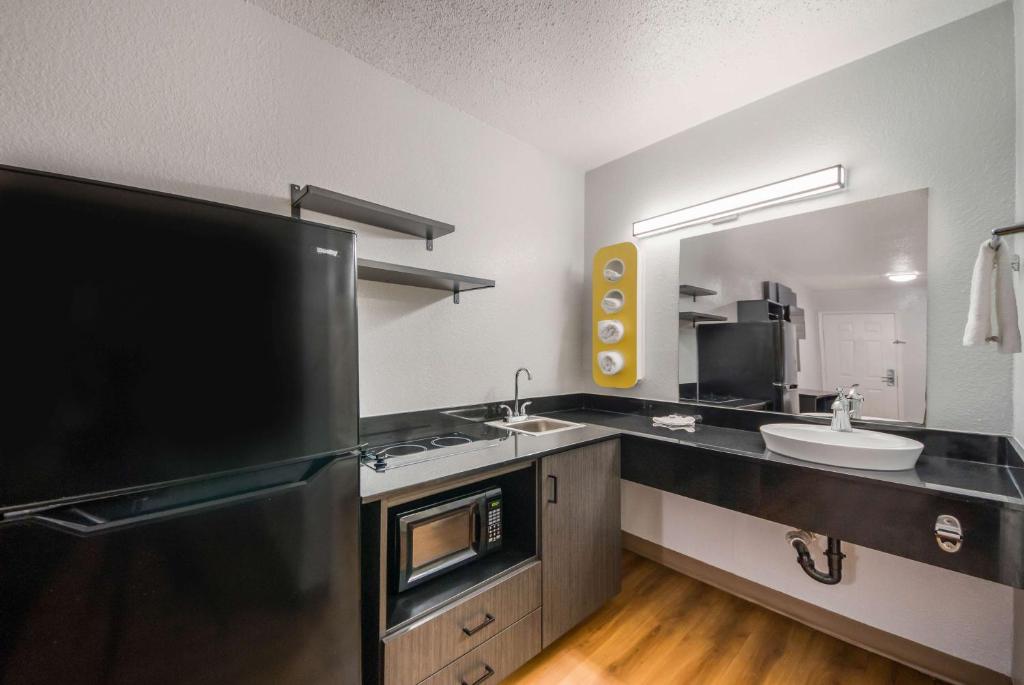 a kitchen with two sinks and a black refrigerator at Studio 6 Laredo, Tx - North I-35 in Laredo