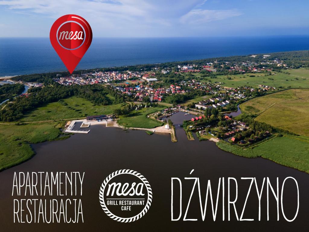 a hot air balloon flying over a body of water at Apartamenty Mesa Grill Restaurant Cafe in Dźwirzyno