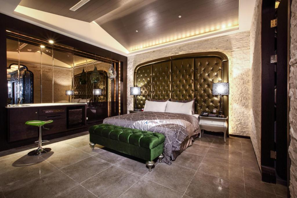 a bedroom with a large bed and a green couch at Icloud Luxury Resort &amp; Hotel in Taichung