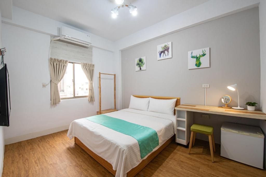 a small bedroom with a bed and a desk at No Smoking INN in Magong
