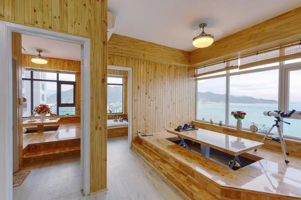 a room with wooden walls and windows and a table at HighSea Nha Trang Apartments in Nha Trang
