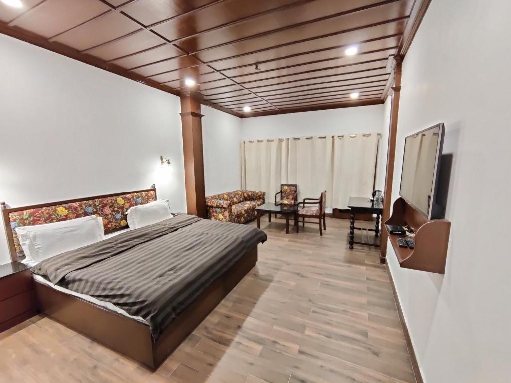 ein Schlafzimmer mit einem Bett und ein Wohnzimmer in der Unterkunft Hotel Himalayan Club in Masuri