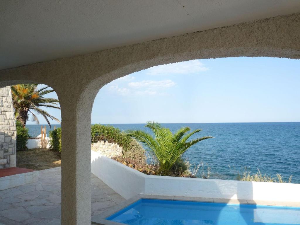 ビナロスにあるBelvilla by OYO Cupedoのスイミングプール付きの家から海の景色を望めます。
