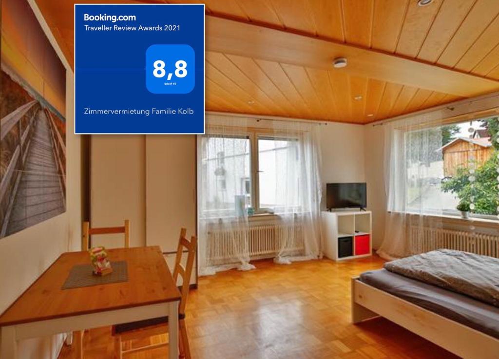 OberessendorfにあるZimmervermietung Familie Kolbのテーブルとベッド1台付きの部屋、ダイニングルームが備わる客室です。