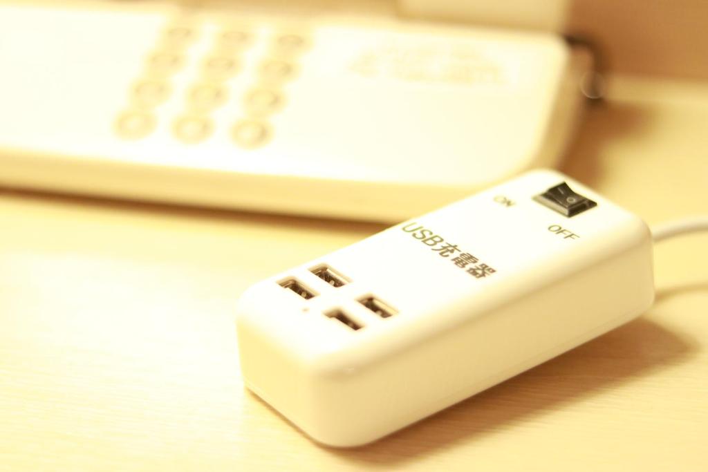 a white remote control sitting on top of a table at Hotel Fujita Fukui in Fukui