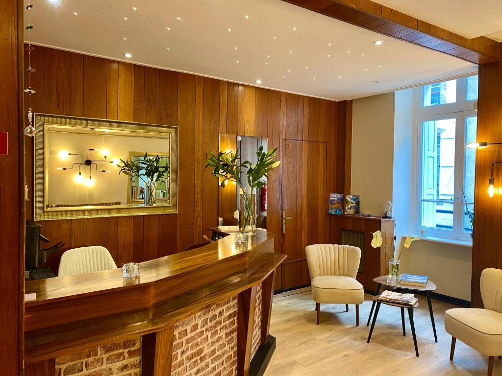 bar w pokoju z drewnianymi ścianami i krzesłami w obiekcie Hôtel Moderna w mieście Cherbourg en Cotentin