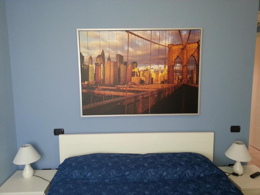 1 dormitorio con 1 cama y una foto en la pared en Sony Affittacamere, en Desenzano del Garda