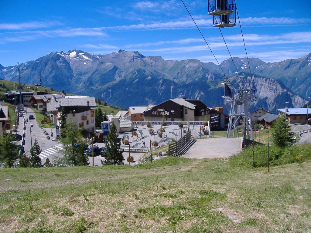a town with a ski lift in the mountains at Langley Hôtel Le Petit Prince in L'Alpe-d'Huez